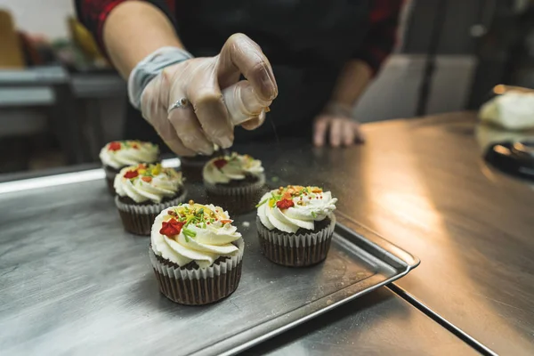 closeup view of a baker decorating Christmas cupcakes at the bakery. High quality photo