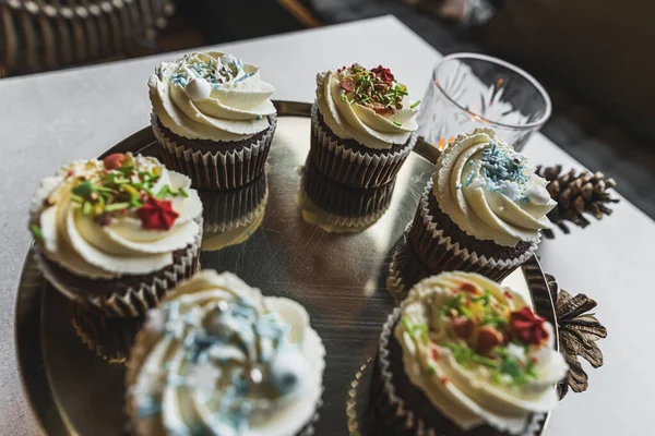chocolate cupcakes with whipped cream, and sprinkles decorated for Christmas dinner, preparing for christmas. High quality photo