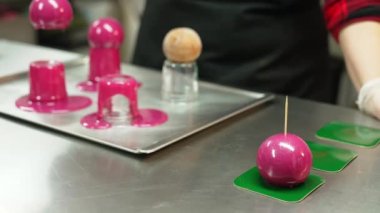medium shot of a female baker putting sticks into the delicious chocolate ball cakes. High quality 4k footage