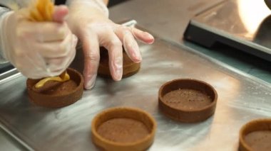 baker piping caramel in circle shapes on a tray, decoating cookies process. High quality 4k footage