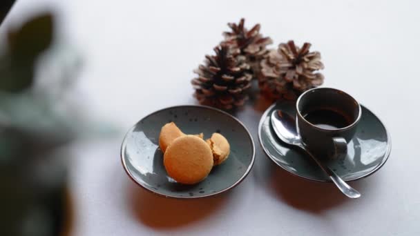 金黄色的金银花与一杯热咖啡在白色的桌子上装饰着松果 节庆甜点 圣诞烘焙 横向室内拍摄 高质量的4K镜头 — 图库视频影像