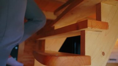 A person in gray tracksuit and white socks walks up the wooden stairs. Close up shot. High quality 4k footage