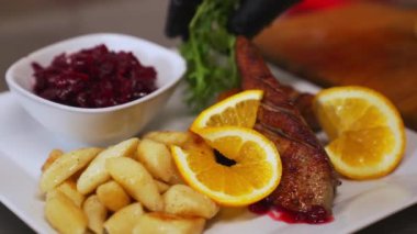 Duck dish. Closeup shot of duck fillet served with potato dumplings and slices of oranges. Combination of modern and traditional cuisine. High quality 4k footage