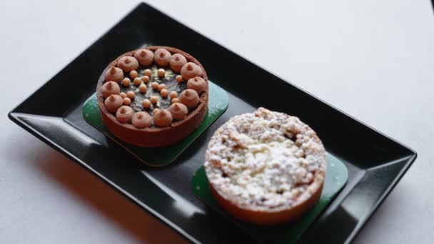 Two Tasty Tarts Lying Black Plate Gray Table Art Confectionery — Stockvideo