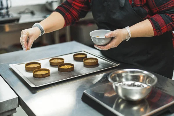 Female Professional Baker Wearing Black Apron Sprinkling Golden Sprinkles Filled — Fotografia de Stock
