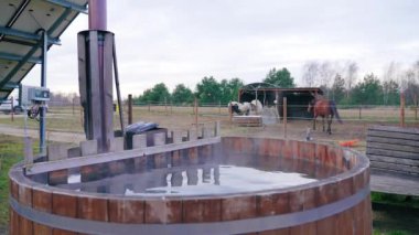 The water is heated in the barrel. The water evaporates. Horses are walking in the background. High quality 4k footage