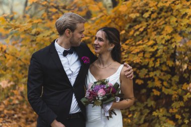 Young Wedding Couple looking at each other in fall park. High quality photo