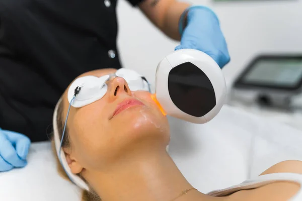 Woman getting an professional laser face treatment. High quality photo