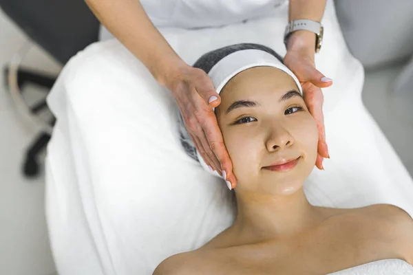Woman getting a face massage by professional massage specialist. High quality photo