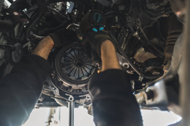 Close shop of two gloved hands doing a clutch replacement. Repair shop concept. High quality photo