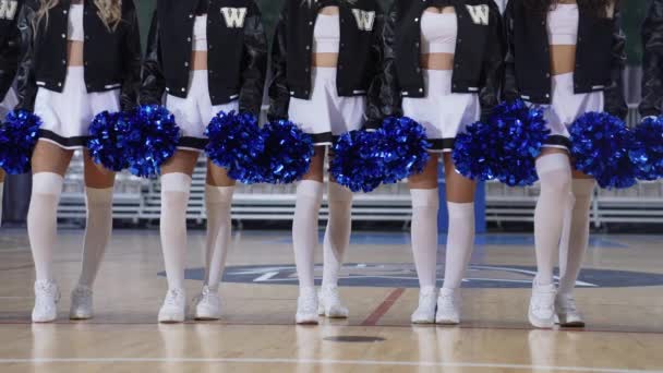 Close Shot Cheerleaders Standing Line Basketball Court Holding Blue Pom — Vídeo de stock