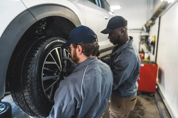 Car Mechanics Replacing Wheels Lifted Automobile Repair Service Station High — Stok fotoğraf