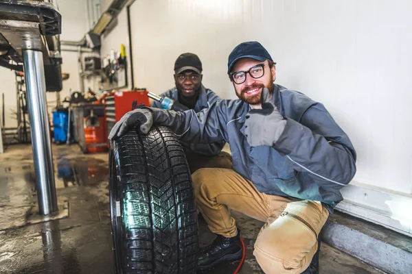 Smiling Car Mechanic Working Garage Changing Cars Wheels Makes Thumbs — Stok fotoğraf