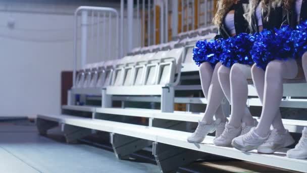 Close Side View Cheerleaders Sitting Row Bench Holding Blue Shiny — Αρχείο Βίντεο