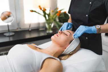 Pragnant Caucasian woman getting an face massage in beauty clinic. High quality photo