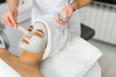 Young beautiful Asian getting an face massage and green algae mask. High quality photo