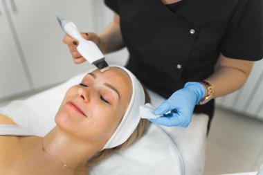 Caucasian woman getting a facial cleanising procedure in beauty clinic. High quality photo