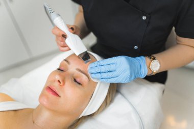 Caucasian woman getting a facial cleanising procedure in beauty clinic. High quality photo