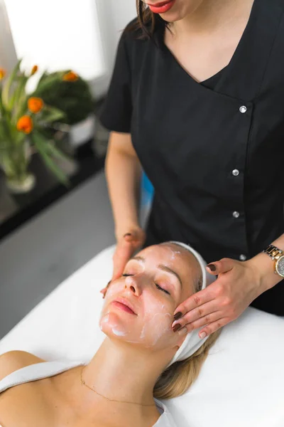 Pragnant Caucasian woman getting an face massage in beauty clinic. High quality photo