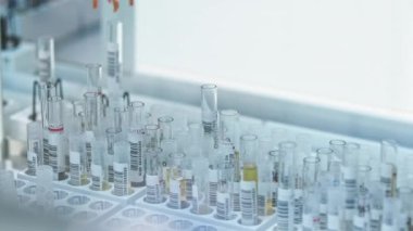 Robot arm picking up one vial from among many others. Test tubes moving in the background. Lab concept. High quality 4k footage