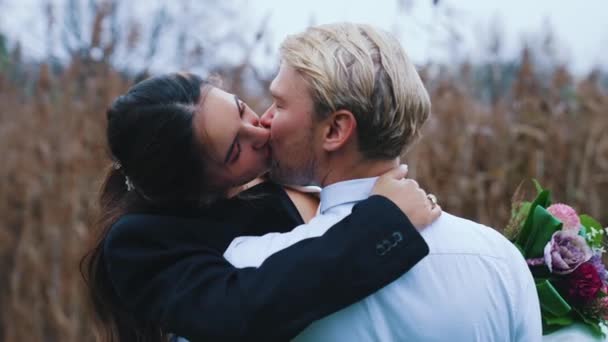 自然の緑の森の中で新婚の花嫁と新郎は優しさの概念を愛するキス 高品質4K映像 — ストック動画