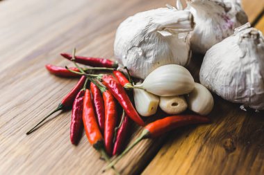 Close-up shot of garlic and chillis decoration on rustic wooden table. Food preparation. Ingredients. Spices. Horizontal indoor shot . High quality photo