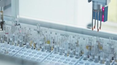 Single test tube in a holder moving along the line of an automated lab. Lab concept. Empty tube holders moving in the background. High quality 4k footage