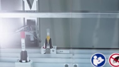 Otomatik bir laboratuvarda çeşitli renk kodlu test tüpleri bir hat üzerinde hareket ediyor. Laboratuvar konsepti. Yakın çekim video. Yüksek kalite 4k görüntü