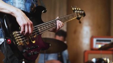 Bas gitarist ve baterist, müzik provaları sırasında modern bir kayıt stüdyosunda. Yüksek kalite 4K görüntü