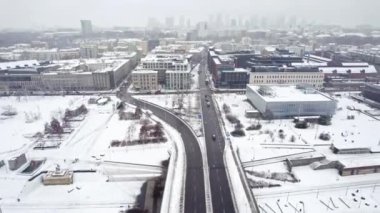 01.22.2023 Varşova, Polonya. Şehir merkezine giden karlı şehir yolunun kuşbakışı videosu. Arka planda gökdelenler. Gri kış gökyüzü. Winter City konsepti. Yüksek kalite 4k görüntü