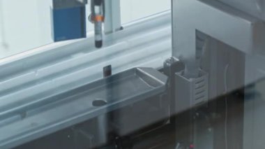Close-up of an automated lab robotic arm picking a test tube up and putting it in a hole. Lab concept. High quality 4k footage