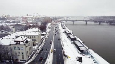 01.21.2023 - Warsaw, Poland. The city of Warsaw covered in snow. Cars going by the river on Wislostrada expressway. Winter city. Aerial view. High quality 4k footage