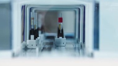 Test tube moving away on and automatic holder and turning right out of sight. Blurred foreground. Lab concept. High quality 4k footage
