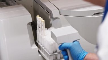 A close shot of a gloved hand putting a tray with test tubes in an automated lab. Lab concept. High quality 4k footage