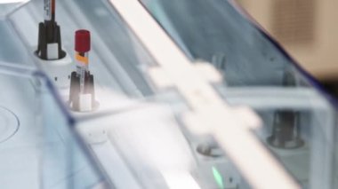 Two blood samples moving on a laboratorys belt conveyor. Blurred foreground. High quality 4k footage