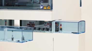 Full shot of blood sample moving on a laboratorys belt conveyor. Blurred foreground. . High quality 4k footage