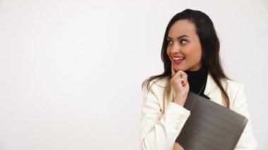 A smiling young woman holding a file looking towards her right for copy space. Concept of applying for a job. High-quality 4k footage