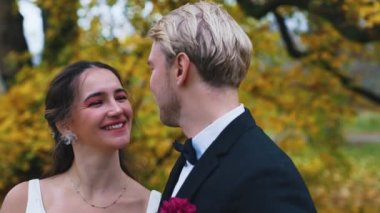 Damat, ormanda fotoğraf çekimi için güzel gelinini öpüyor. Yüksek kalite 4k görüntü