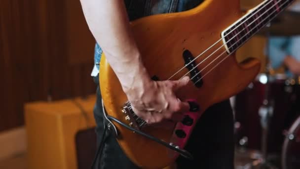 Seorang Gitaris Memainkan Gitar Bass Memetik Senar Dan Memetik Catatan — Stok Video