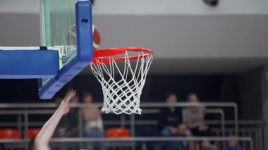 Basketbolcu potaya bir top atıyor, kapalı alandaki spor konseptini kapatıyor. Yüksek kalite 4k görüntü