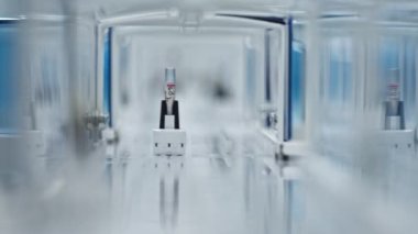 Test tube getting closer to the camera while being on a laboratorys belt conveyor. Blurred foreground. High quality 4k footage