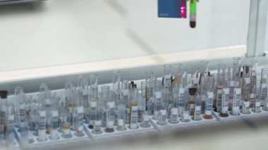 Blood sample being placed in test tube holder by the automatic machine. Blurred background. High quality 4k footage
