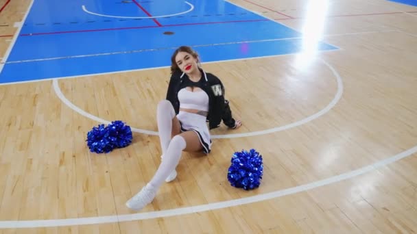 Long Haired Cheerleader Sitting Floor Posing Blue Pom Poms Next — Video