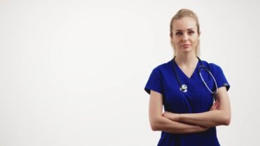 Female nurse posing with stethoscope and crossed arms against a white background. High quality 4k footage