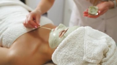 Cosmetology specialist applying facial mask using a stick spa beauty procedures. High quality 4k footage