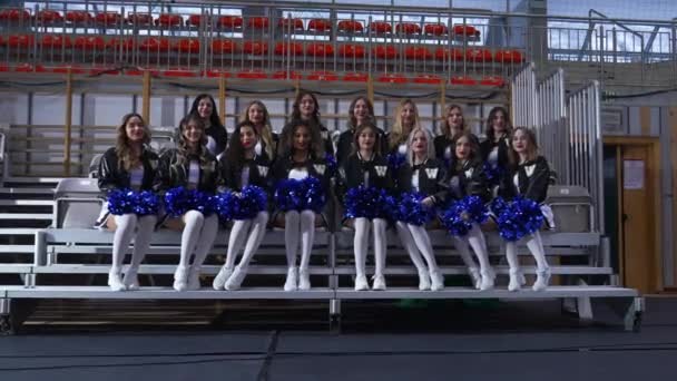 Cheerleaders Black White Uniforms Holding Blue Pompoms Sitting Confidently Photos — Stock Video