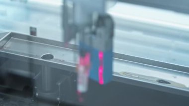 Robot bir kol tarafından alınan ve metal bir korkulukta bir deliğe sokulan bir şişe. Otomatik laboratuvar. Laboratuvar konsepti. Yüksek kalite 4k görüntü