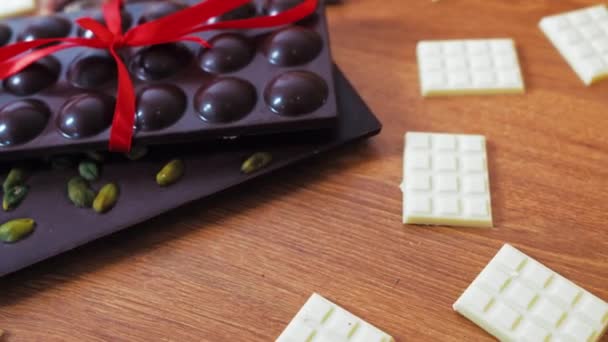 Dark Chocolate Bars Decorated Red Ribbon Surrounded Miniature White Chocolate — Video