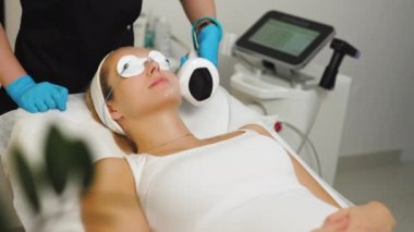 Woman with eyes covered during thermolifting for reducing wrinkle improving tone. High quality 4k footage