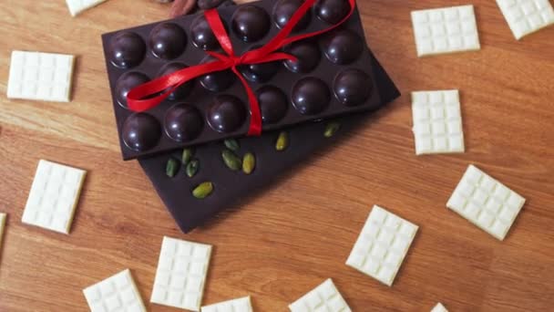 Top View Dark Chocolate Bars Pistachios Tied Red Ribbon Miniature — Vídeo de Stock